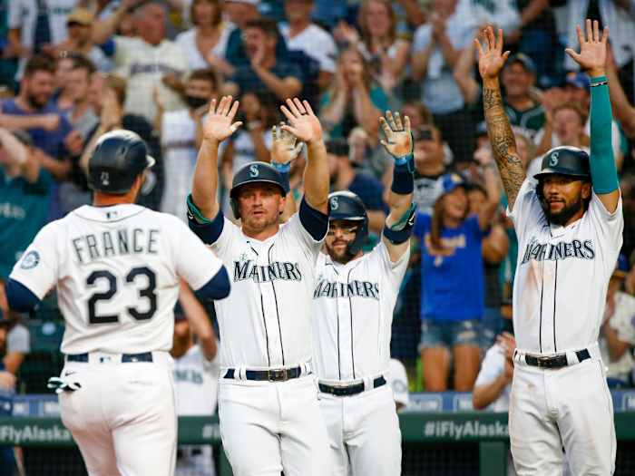 Jul 26, 2021; Seattle, Washington, USA; Seattle Mariners third baseman Kyle Seager (15, left), first baseman Luis Torrens (22) and shortstop J.P. Crawford (3, right) greet designated hitter Ty France (23) as he scores a run against the Houston Astros during the fourth inning at T-Mobile Park. Seager and Crawford also scored runs on the play.